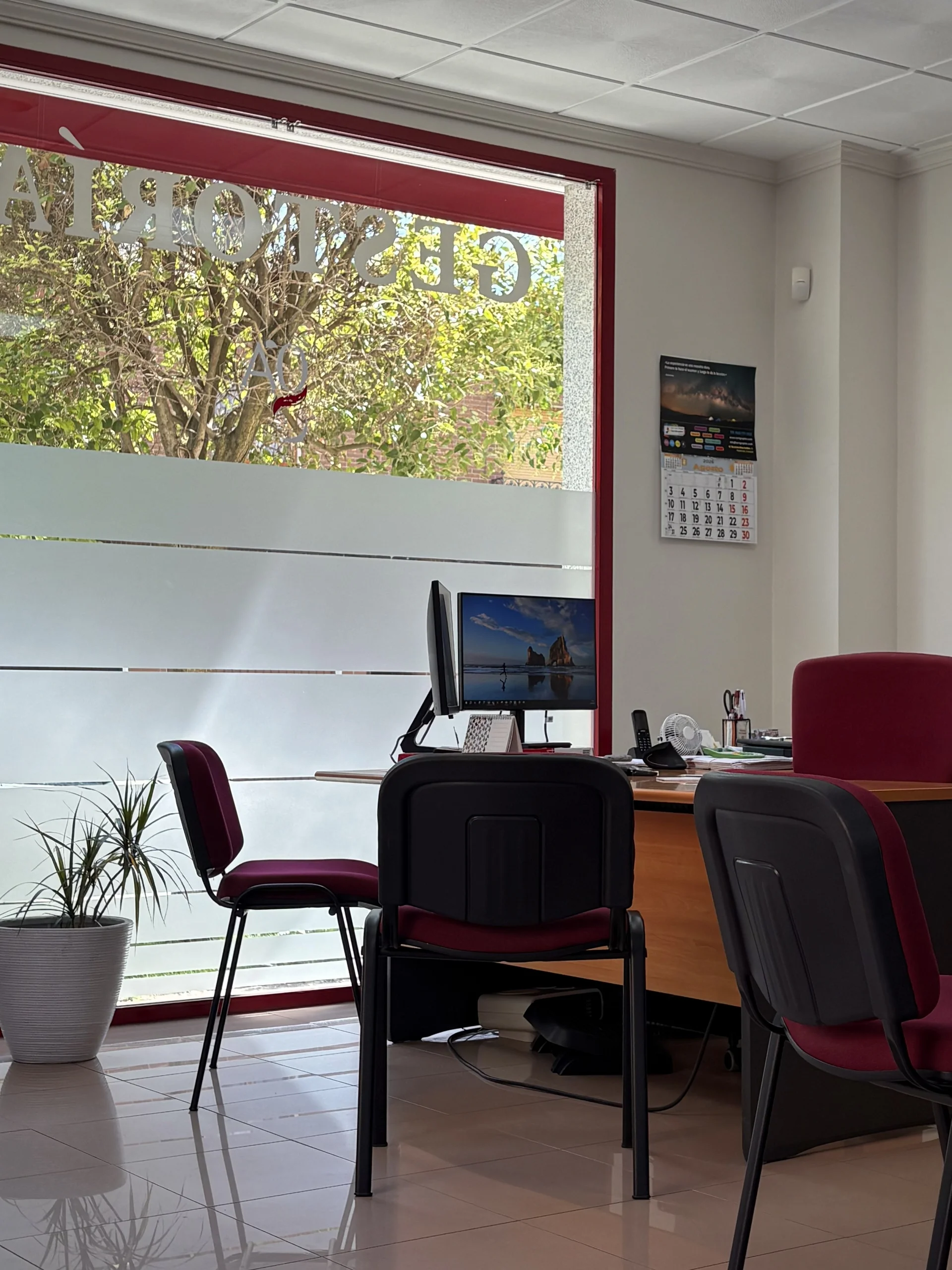 Zona de atención al cliente con escritorio junto a cristalera